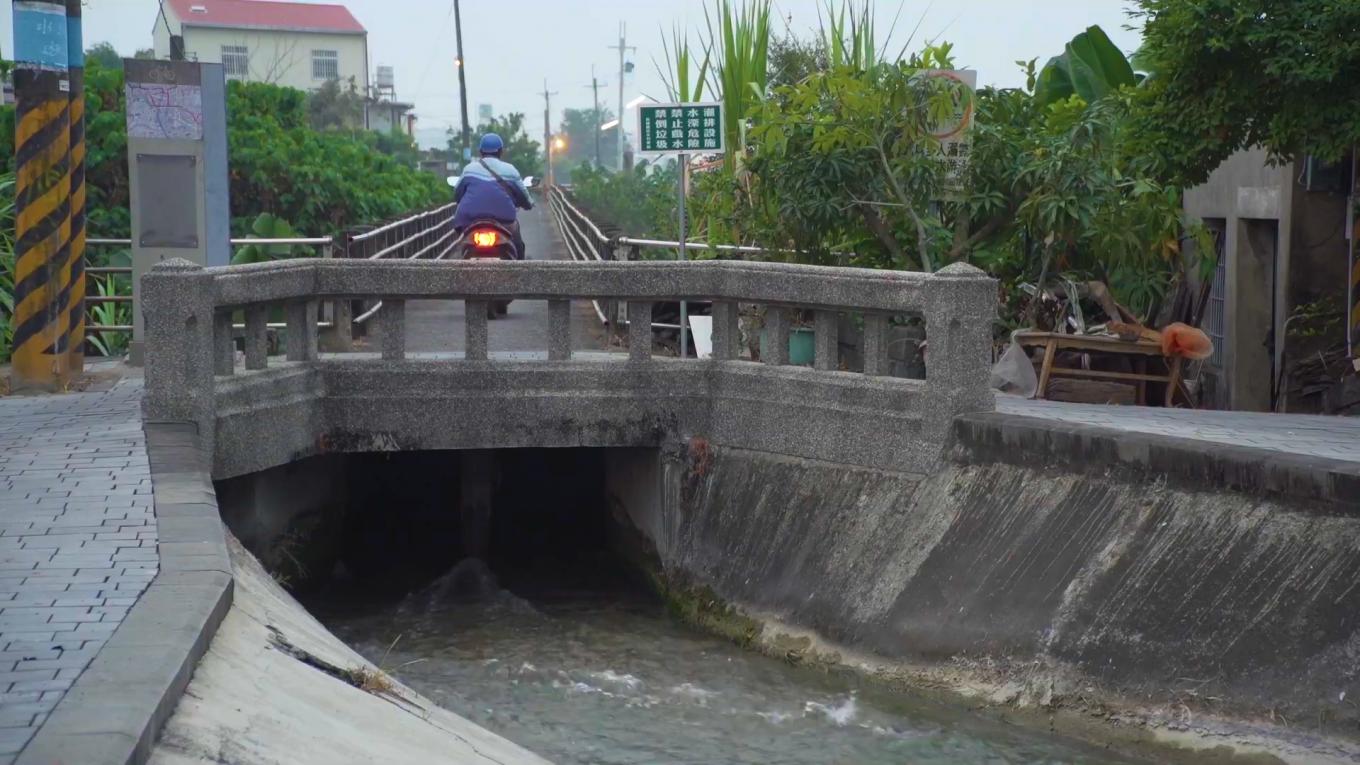 獅子頭圳:美濃水橋，1909年始建(木橋)，1926重建，1927年完工,橋上人車走，橋下流水流。