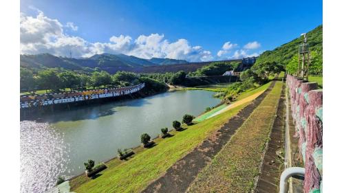 走在壩頂觀景區，石門村景色盡收眼底。遠眺蓄水區全景，悠悠白雲與綠色山脈倒映在湖面，令人心曠神怡.