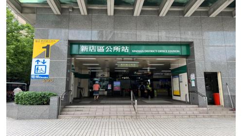 新店區公所站為地下二層車站，設有2處出入口，出口1位於車站西側、出口2位於車站東側，無障礙電梯位於出口1。出口1有聯合開發大樓。【圖/1號出口，北新路一段，捷運共構住宅大樓】
 